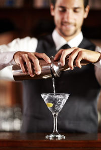 Bartender making cocktail at bar