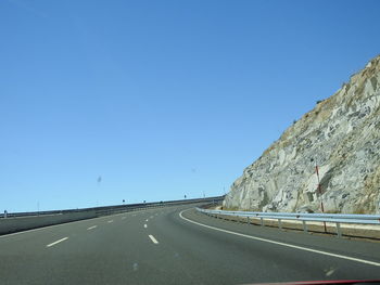 Road against clear blue sky