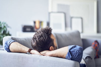 Relaxed man lying on sofa