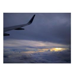 Airplane flying in sky during sunset