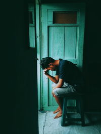 Side view of depressed man sitting at home