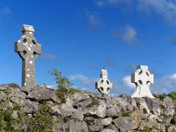 Crosses at cemetery against blue sky