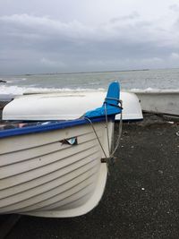 Deck chairs on beach against sky