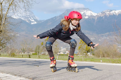 Full length of girl skating on road