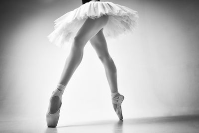 A photo of a ballerina's legs in pointes showing a pa during a performance