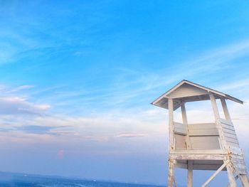 Low angle view of hut on beach against blue sky