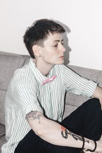 Portrait of young man sitting on sofa at home