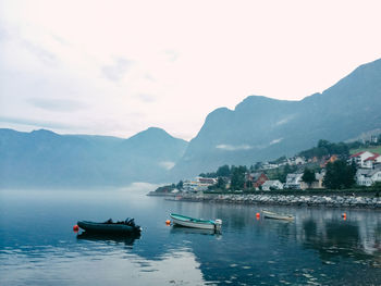 Boats in river with mountains in background