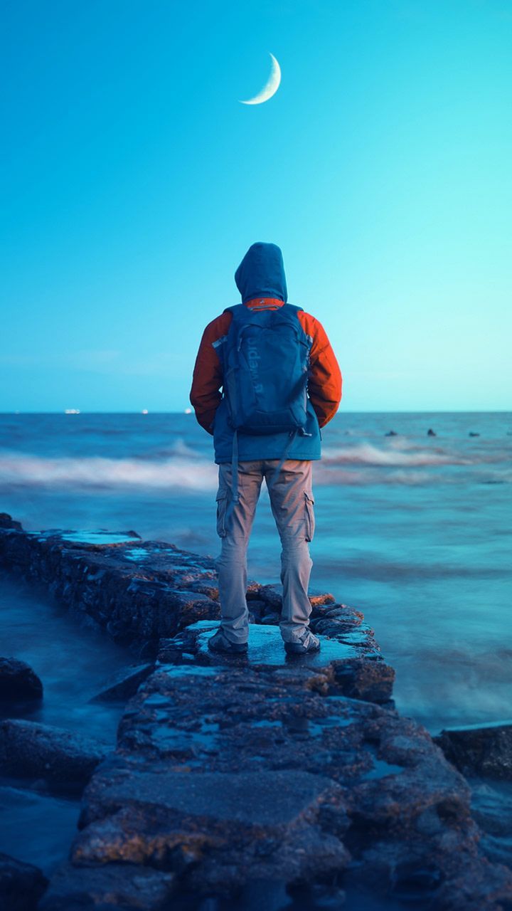 blue, ocean, sea, sky, water, one person, land, horizon, beach, rear view, nature, full length, standing, rock, beauty in nature, horizon over water, scenics - nature, wave, coast, men, adult, clear sky, moon, leisure activity, vacation, holiday, tranquility, tranquil scene, trip, outdoors, travel destinations, travel, exploration, environment, shore, night, adventure, idyllic, motion, lifestyles