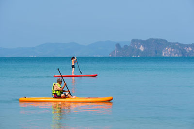 Man fishing in sea against sky