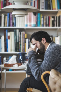Young depressed patient with facial tissue crying during therapy session
