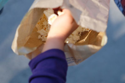 Cropped hand holding paper with popcorn