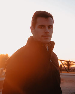 Portrait of young man looking at camera against sky