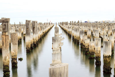 Panoramic view of wooden posts at princes pier in water against sky