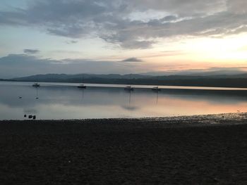 Scenic view of lake against sky at sunset