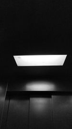 Low angle view of illuminated light bulbs in darkroom