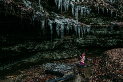 Woman standing on rock in forest