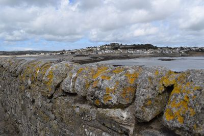 Rock formation on beach against sky