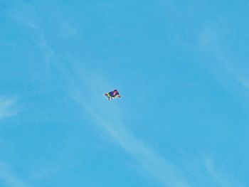 Low angle view of kite flying against clear blue sky