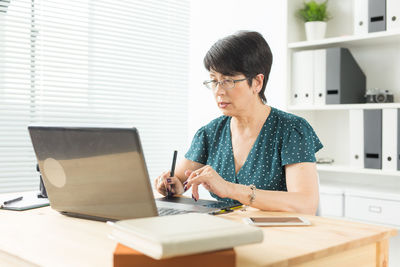 Young woman using laptop on table