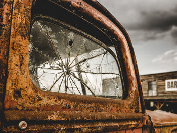 Close-up of rusty wheel against sky