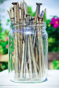 Close-up of nails in jar on table