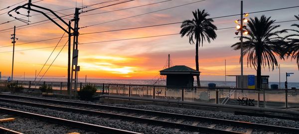 Railroad tracks against sky during sunset