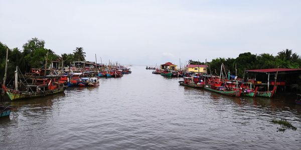 Boats moored in river against sky