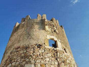 Low angle view of old building against clear blue sky