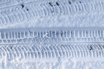 Close up view tire tracks at the surface of fresh fallen snow