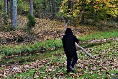 Rear view of woman walking in forest