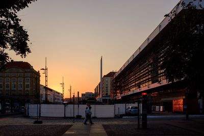 Silhouette buildings against clear sky at sunset