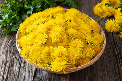 High angle view of yellow flowering plant in basket on table