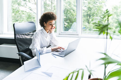 Female business professional using laptop in office