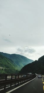 Road leading towards mountains against sky