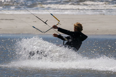 Side view of person kiteboarding in sea