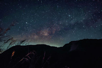 Scenic view of silhouette mountain against star field