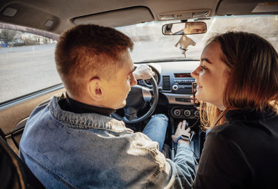 Young trendy couple discussing their route in the car. love on a travel