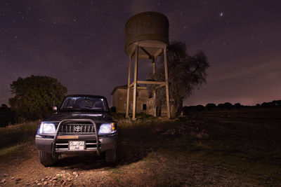 Built structure on field against sky at night