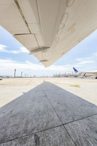 Under wing view of jet airliner showing tarmac