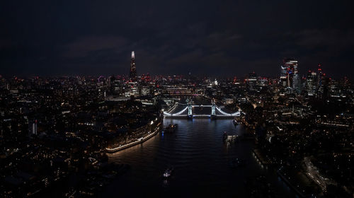 Aerial view to the illuminated tower bridge and skyline of london, uk