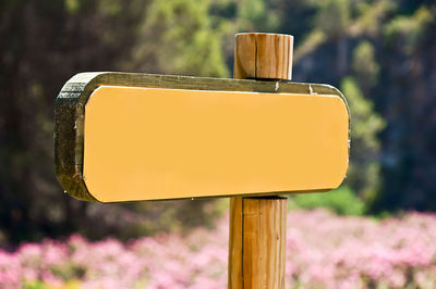 Close-up of arrow sign against trees