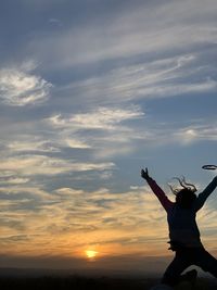 Low angle view of silhouette woman standing against sky during sunset in norco, california 