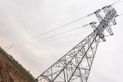 Low angle view of electricity pylon against sky