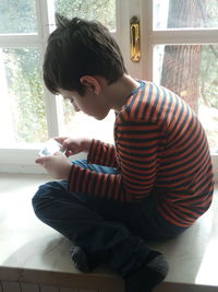 Young man sitting in window