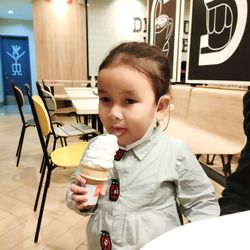 Portrait of smiling young woman eating ice cream