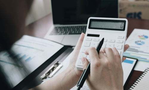 Midsection of man using laptop on table