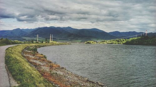 Scenic view of road amidst river and mountain