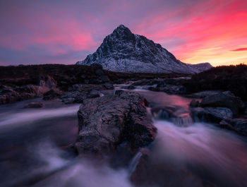 Scenic view of stream against sky during sunset