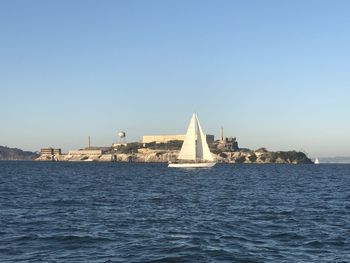 View of sea and buildings against clear sky